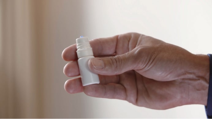 Hand holding eye-drops bottle