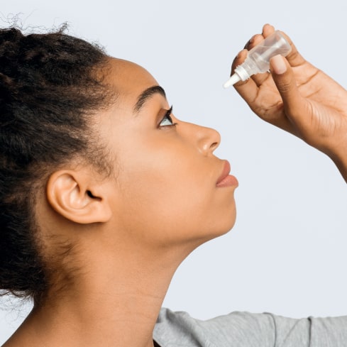 Woman applying eye-drops