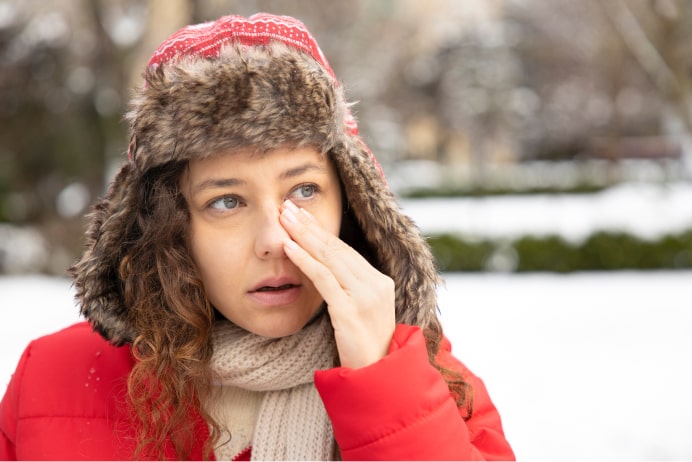 Woman outside rubbing her eyes