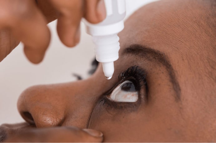 Woman applying eye-drops