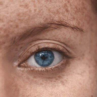 Close-up of eye on girl's freckled face
