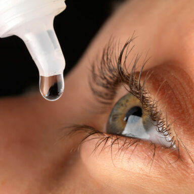 Close up of eye drop over woman's eye