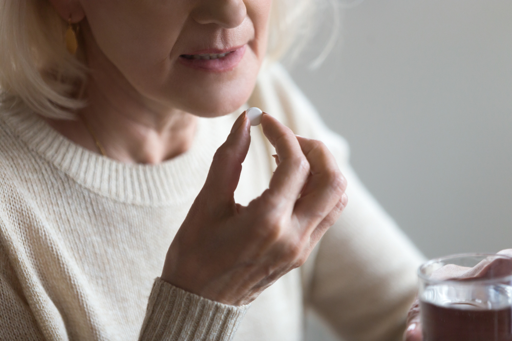 Lady taking a pill with water