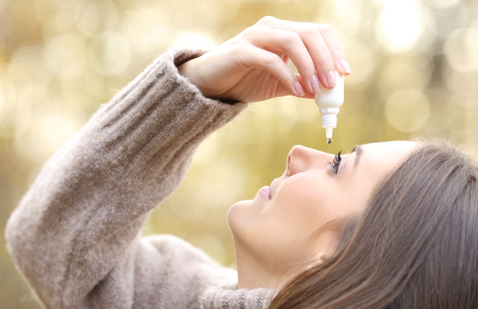 Woman applying eye drops